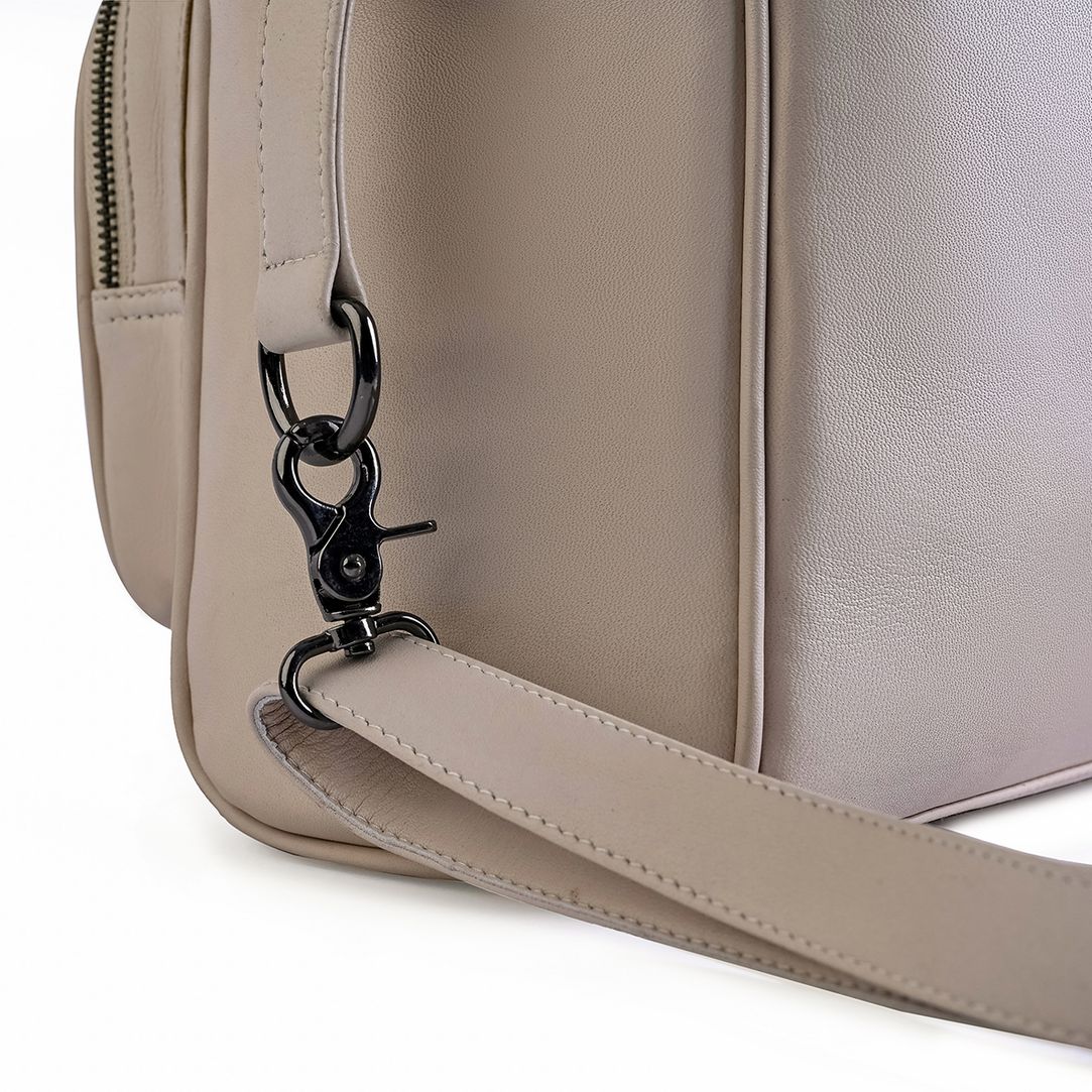Wickeltasche aus cremefarbenem Leder – Detail Karabinerhaken